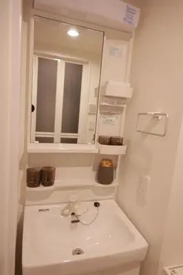 a white bathroom with a sink and a mirror at Mi-HOTEL KOMAGOME in Tokyo