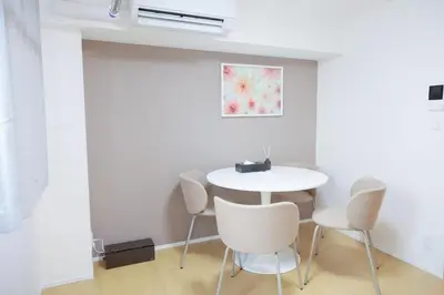a white dining room with a white table and chairs at Mi-HOTEL KOMAGOME in Tokyo