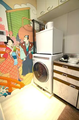 a kitchen with a washing machine and a painting on the wall at 10min Meguro Sta 18min Shibuya Sta Max2 SAKURA meguro203 in Tokyo