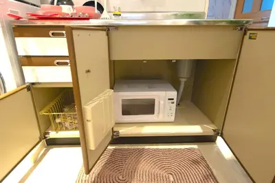 a kitchen with a microwave under a sink at 10min Meguro Sta 18min Shibuya Sta Max2 SAKURA meguro203 in Tokyo