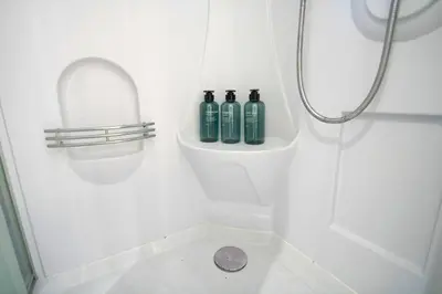 a white bathroom with three bottles in a shower at 10min Meguro Sta 18min Shibuya Sta Max2 SAKURA meguro203 in Tokyo