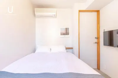 a bedroom with a bed and a flat screen tv at Hotel Residence Asakusa by unito in Tokyo