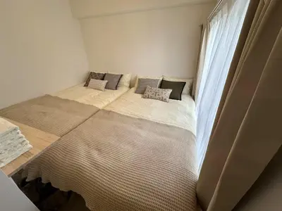 a bedroom with two beds and a window at \u65b0\u5927\u4e45\u4fdd\u6b65\u884c6\u5206\u949f \u4e1c\u4eac\u90fd\u5fc3\u5546\u5708 in Tokyo