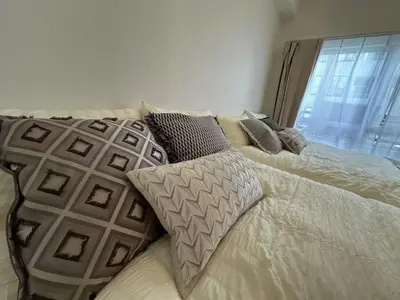 a bed with white sheets and pillows with a window at \u65b0\u5927\u4e45\u4fdd\u6b65\u884c6\u5206\u949f \u4e1c\u4eac\u90fd\u5fc3\u5546\u5708 in Tokyo