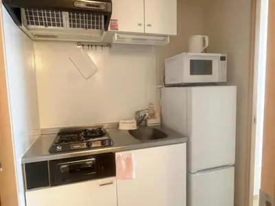 a small kitchen with a stove and a refrigerator at ARSTAY Ikebukuro - Vacation STAY 65934v in Tokyo