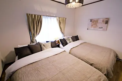 a bedroom with two beds in front of a window at Muse\u516b\u5e832F in Tokyo