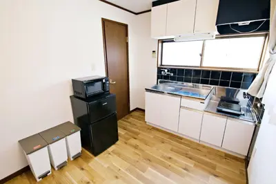 a kitchen with white cabinets and a black refrigerator at Muse\u516b\u5e832F in Tokyo
