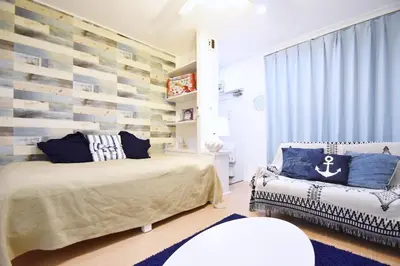 a bedroom with two beds and a bench at \u6771\u30b0\u30ea\u30fc\u30f3\u30cf\u30a4\u30c4 302 in Tokyo