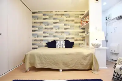 a bedroom with a bed and a brick wall at \u6771\u30b0\u30ea\u30fc\u30f3\u30cf\u30a4\u30c4 302 in Tokyo