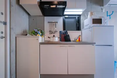 a kitchen with white cabinets and a white refrigerator at Ueno Grand Maison Hotel in Tokyo