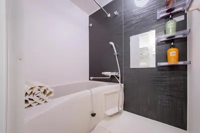 a bathroom with a white tub and a black wall at Ueno Grand Maison Hotel in Tokyo