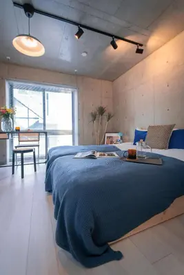 a bedroom with a large bed with a blue blanket at Ueno Grand Maison Hotel in Tokyo