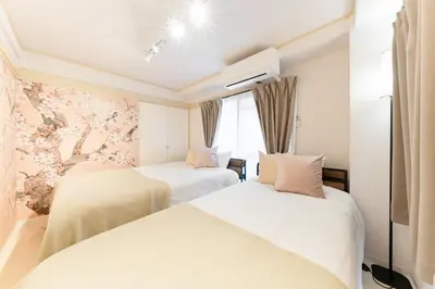 a hotel room with two beds and a window at Japanese Art Room, 2Bed Room, 4Bed, Near Metro&JR station in Tokyo