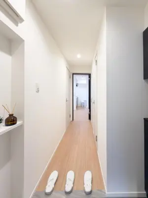 a hallway with white walls and white shoes on the floor at Asakusa 801 Triple Room in Tokyo