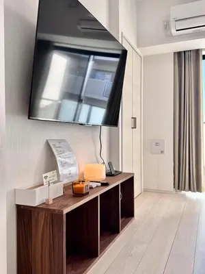 a room with a desk with a television on the wall at Asakusa 802 Triple Room in Tokyo