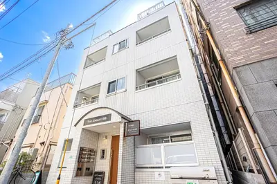 a white brick building with an entrance to it at Emilio Nishi Shinjuku in Tokyo
