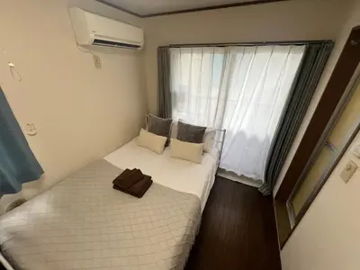 a small bedroom with a bed and a window at \u62bc\u4e0a\u8f66\u7ad9\u6b65\u884c5\u5206\u949f\u7684\u65b0\u623f\u6e90 \u514d\u8d39wifi \u7535\u8f66\u76f4\u8fbe\u6210\u7530\u673a\u573a\u548c\u7fbd\u7530\u673a\u573a in Tokyo