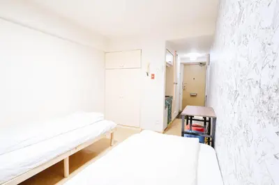 a white room with two beds and a table at Shinjuku Kabukicho! Shinjuku Center\u65b0\u5bbf\u4e2d\u5fc3! !3min walk! JR \u65b0\u5bbf!\u5730\u94c1\u7ad9\u6b65\u884c3\u5206! \u65b0\u5bbf\u6b4c\u821e\u4f0e!\u8457\u540d\u8fde\u9501\u5927\u578b\u516c\u5bd3!\u4e00\u5c4224\u5c0f\u65f6\u4fdd\u5b89\u5e38\u9a7b! 625 in Tokyo