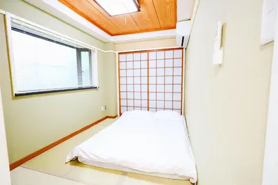 a small room with a bed and a window at \u5317\u65b0\u5bbf2\u5ba41\u5385\u516c\u5bd3#\u667a\u80fd\u9a6c\u6876#\u5e72\u6e7f\u5206\u79bb#Shinjuku 2bed rooms1#2 in Tokyo