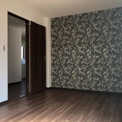 an empty room with a wall with a floral wallpaper at \u4e09\u30ce\u8f2a301 in Tokyo