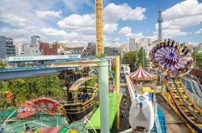 an amusement park with a roller coaster and a carnival at \u4e09\u30ce\u8f2a301 in Tokyo