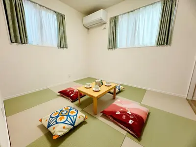 a living room with a table and two pillows at Hao Bros Home Gemini A in Tokyo