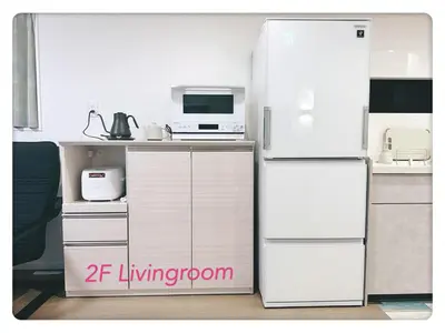 a kitchen with a white refrigerator and a microwave at Hao Bros Home Gemini A in Tokyo