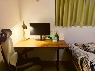 a desk with a computer on top of it next to a bed at Hao Bros Home Gemini A in Tokyo