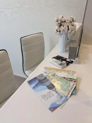 a table with a vase of flowers and a magazine at Tulip Asakusa in Tokyo