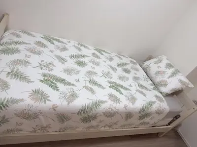 a bed with a white sheet with pine needles at Tulip Asakusa in Tokyo