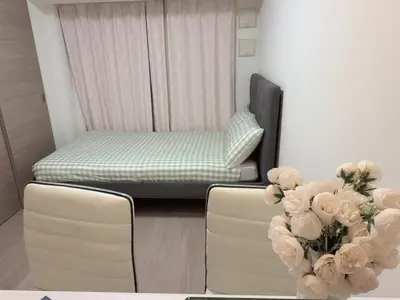 a room with a bed and two chairs and flowers at Tulip Asakusa in Tokyo