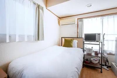 a bedroom with a white bed and a window at T s\u30cf\u30a4\u30e0 in Tokyo