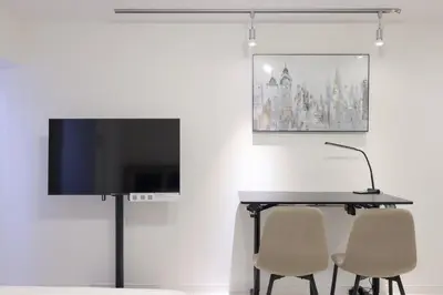 a table with two chairs and a television on a wall at AlTERNA\u6075\u6bd4\u5bff in Tokyo