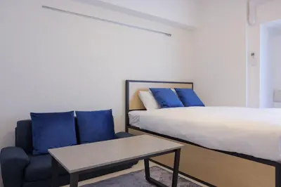 a bedroom with a bed and a chair and a table at AlTERNA\u6075\u6bd4\u5bff in Tokyo