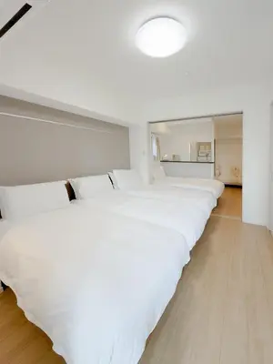 a row of white beds in a room at Asakusa 701 Quad Room in Tokyo