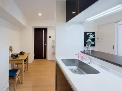 a white kitchen with a sink and a table at Asakusa 701 Quad Room in Tokyo