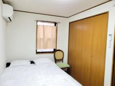 a bedroom with a bed and a door and a chair at \u6771\u9577\u5d0e\u6238\u5efa\u3066 \u6771\u9577\u5d0e\u99c5\u304b\u3089\u5f92\u6b692\u5206 in Tokyo