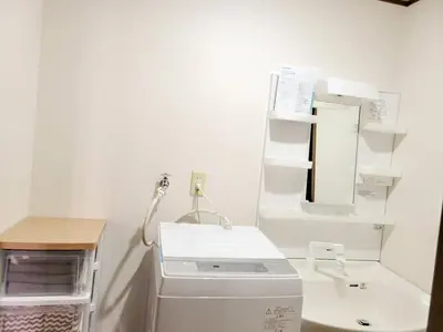 a white bathroom with a sink and a mirror at \u6771\u9577\u5d0e\u6238\u5efa\u3066 \u6771\u9577\u5d0e\u99c5\u304b\u3089\u5f92\u6b692\u5206 in Tokyo