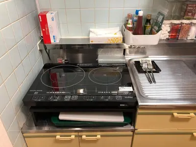 a kitchen with a counter with a stove top at A Cosy Daikanyama Stay at the Anime Sanctuary in Tokyo