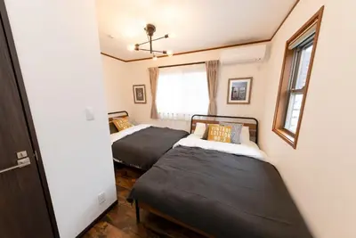 two beds in a small room with a window at \u30a8\u30d0\u30fc\u30db\u30ef\u30a4\u30c8\u6771\u5411\u5cf6 in Tokyo
