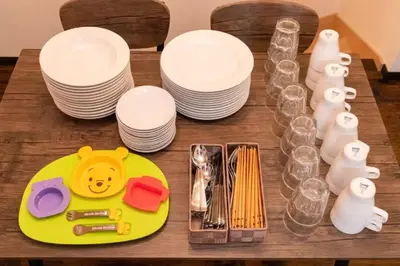 a table with plates and dishes and a plate with a smiley face on at \u30a8\u30d0\u30fc\u30db\u30ef\u30a4\u30c8\u6771\u5411\u5cf6 in Tokyo
