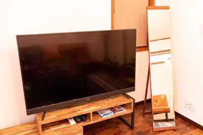 a large flat screen tv sitting on a entertainment center at \u30a8\u30d0\u30fc\u30db\u30ef\u30a4\u30c8\u6771\u5411\u5cf6 in Tokyo