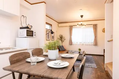 a kitchen and dining room with a wooden table and chairs at \u30a8\u30d0\u30fc\u30db\u30ef\u30a4\u30c8\u6771\u5411\u5cf6 in Tokyo
