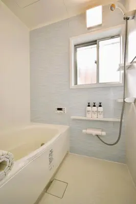 a white bathroom with a tub and a window at Shinkoiwa 3BR house in Tokyo