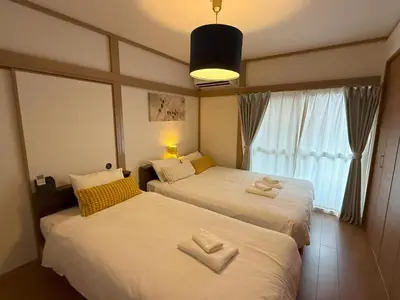two beds in a hotel room with towels on them at Shinkoiwa 3BR house in Tokyo