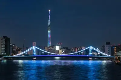a blue bridge over a river with a city at night at Shinkoiwa 3BR house in Tokyo