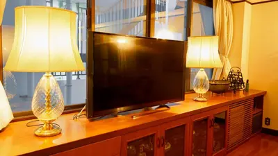 two lamps on a entertainment center with a flat screen tv at \u5343\u5e74\u90b8 in Tokyo