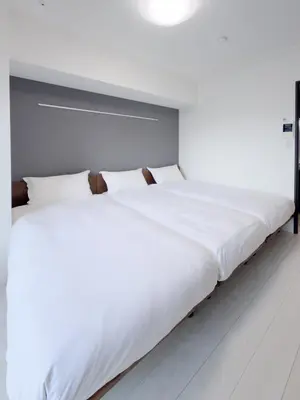 two large white beds in a room with white walls at Asakusa 702 Triple Room in Tokyo