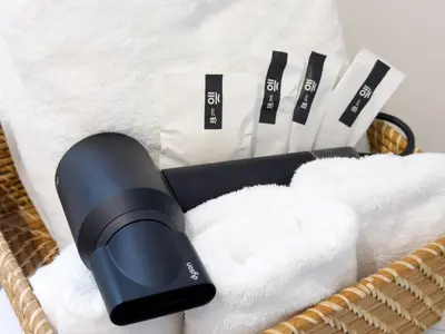 a basket with a hair dryer and towels at Asakusa 602 Triple Room in Tokyo