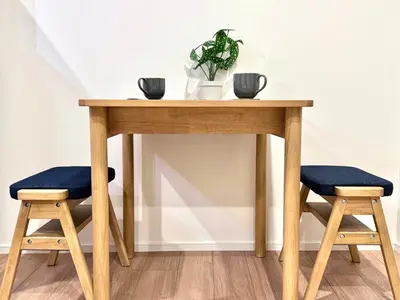 a wooden table with a plant and two stools at Asakusa 501 Quad room in Tokyo